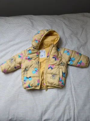 M&S Baby Puffer Jacket 6–9 maanden Geel met vlinderkap – Nooit gebruikt